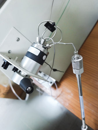 A manual HPLC injection valve mounted on an instrument, connected via tubing to a stainless steel...
