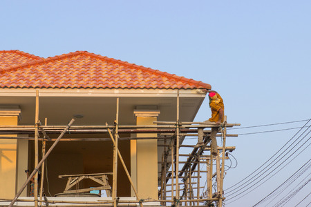 man worker on scaffold painting roofのeditorial素材