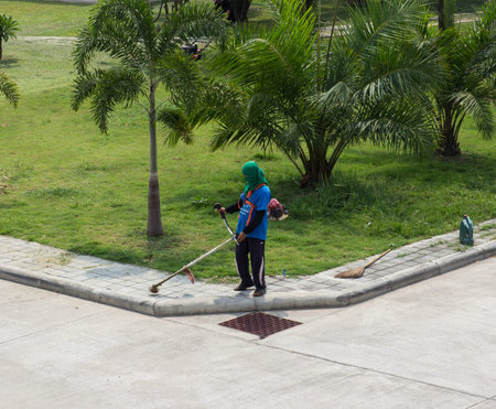 worker use lawnmower to trim grass lawn