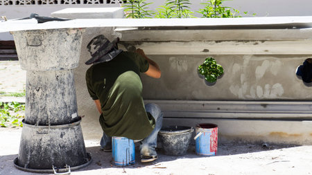 worker using trowel to apply cement on temple wallの写真素材