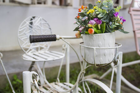 white small decorating bicycle with flower bouquet in the gardenの写真素材