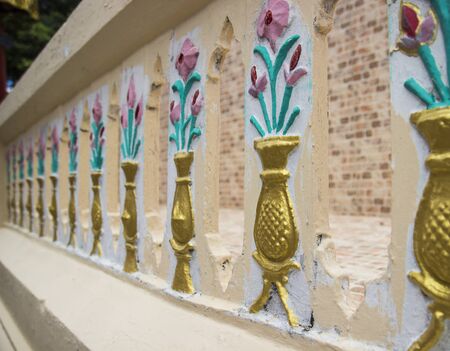 flower in vase sculpture on banister pattern backgroundの写真素材