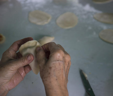 people's hand is wrapping taro in curry puff doughの写真素材