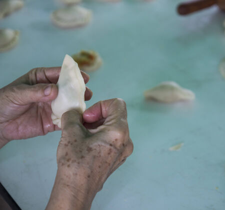 people's hand is wrapping taro in curry puff doughの写真素材