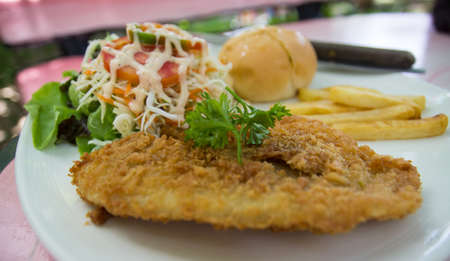 fried fish fillet with salad, bun and French fried potatoesの写真素材