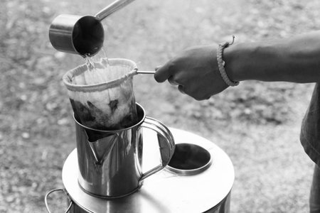 seller hand holding the coffee bag for filtering coffee to the metal container