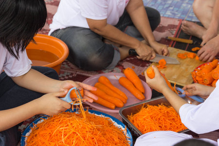 Khonkaen, Thailand - October 26, 2014: People slice and chop carrot for cooking papaya salad at Wiweksikkaram Forest Monastery in Pon district.のeditorial素材