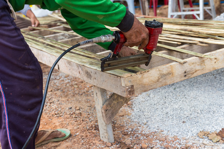 the view of worker's hand using the drill to assemble the wooden seatの写真素材