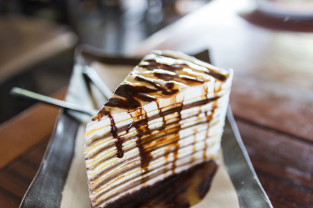 piece of chocolate crepe cake with chocolate sauceの写真素材