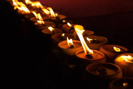 light of many candles glowing at nightの写真素材