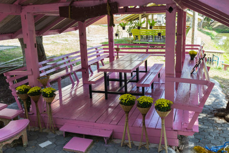 pink wooden gazebo decorating with yellow flower potの写真素材