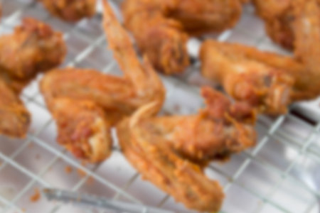 blurry image of many pieces of fried chicken wing limb on the sieve