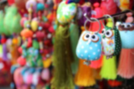 blurry image of colorful handmade souvenir key chain selling at the marketの写真素材