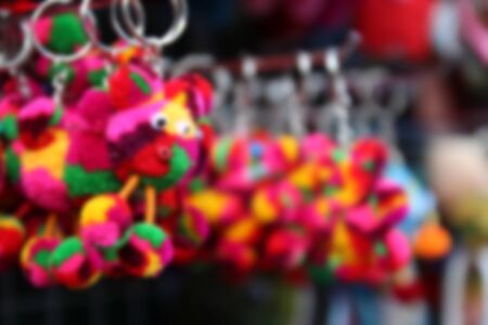 blurry image of colorful handmade souvenir key chain selling at the marketの写真素材