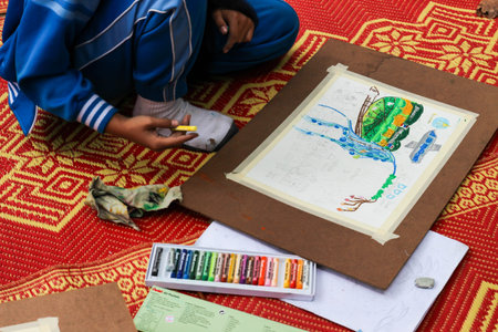Chiangmai, Thailand - December 18, 2014: The asian boy is painting crayon color on her drawing for...