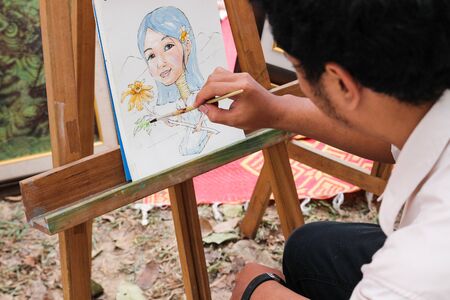 Chiangmai, Thailand - December 18, 2014: The artist is painting asian hill tribe girl artwork in royal project fair at Chiangmai university.のeditorial素材