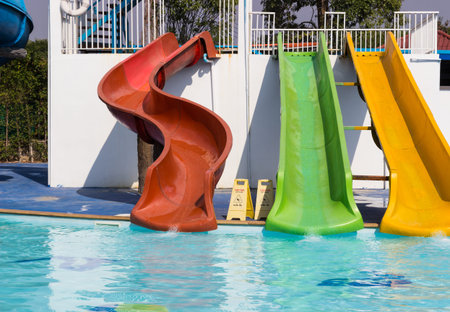 colorful slider beside swimming pool in water park