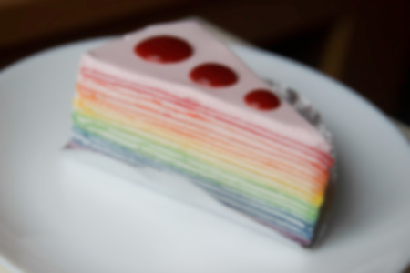 blurry defocused image of rainbow crepe cake with strawberry sauce topping for backgroundの写真素材