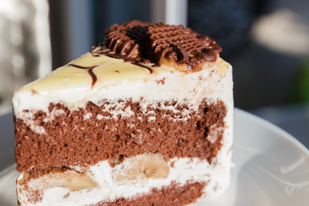 piece of chocolate cake with cream and bananaの写真素材
