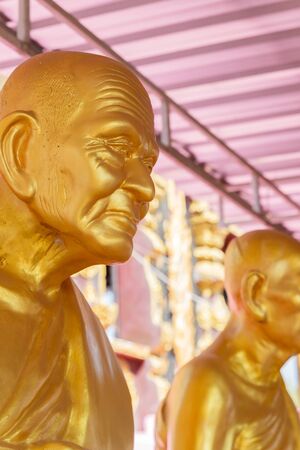 golden buddhism monk statue in asian templeの写真素材