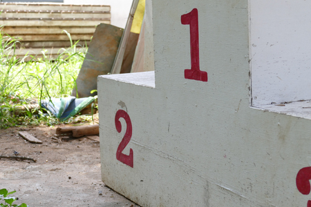old dirty white medal podium with number in red colorの写真素材