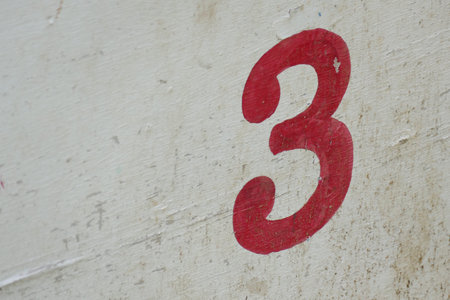 number three painted in red on white wooden board