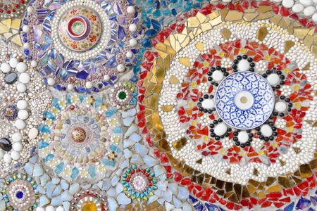 the art design of the colorful broken tile, bead, bowl and stone decorating on temple wall for abstract backgroundの写真素材