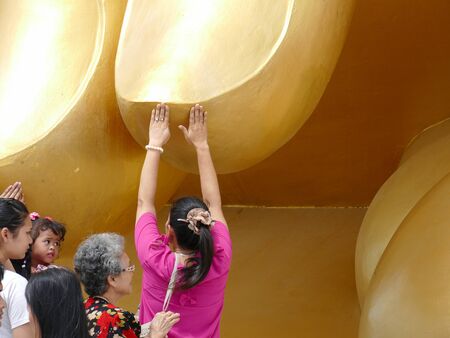 Ang Thong, Thailand - August 1, 2015: buddhist people touch the finger of big golden buddha statue in Muang temple.のeditorial素材