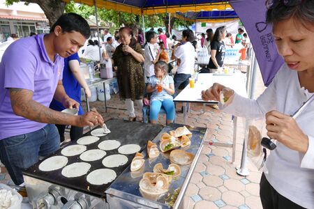 Chiang Mai, Thailand -  July 26, 2015: The man is grilling thailand traditional filled pancake tart for give for free for any people who participating in Dhamma talk fair arranged at Suandok temple.のeditorial素材
