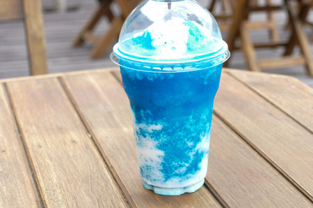 cup of blue lemon smoothie on wooden tableの写真素材