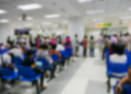 blurry defocused image of people standing and sitting in public hospitalの写真素材