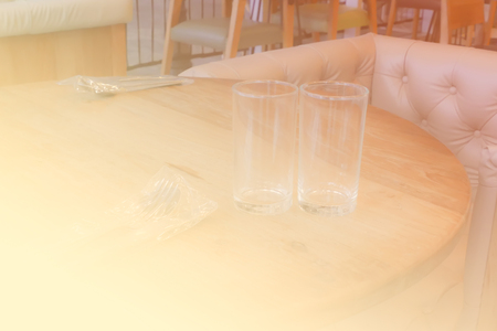 beige knobbed leather armchair and fork, spoon, glass on wooden table (color filter, vintage tone and soft focus)の写真素材
