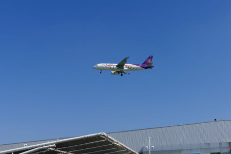 Chiang Mai, Thailand - December 1, 2015: The airplane of Thai Smile Air is flying in blue sky in Chiang Mai, Thailand on December 1, 2015.のeditorial素材