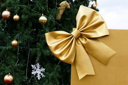 gift box present with golden ribbon and christmas tree for christmas and new year conceptの写真素材