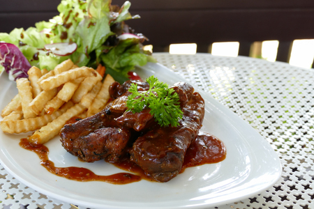 pork spare ribs barbecue serving with french fried and lettuce saladの写真素材