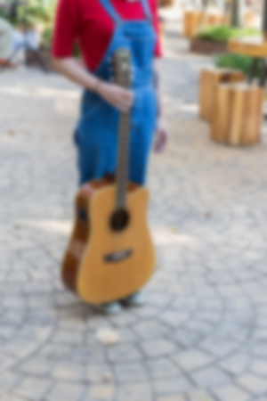 girl wearing blue jeans and sneaker standing and holding guitarの写真素材