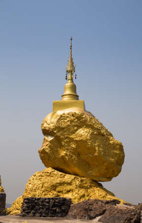 golden buddhism pagoda on big stone on the hillの写真素材