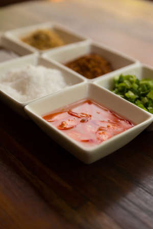 set of thailand condiment seasoning for rice gruel (fried garlic, dried chili, sugar, fish sauce, vinegar, vegetable)の写真素材