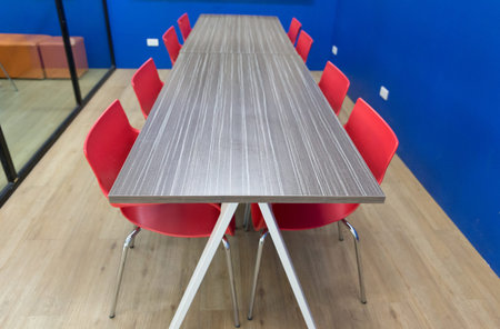 red chair and wooden table in meeting conference room with blue wallのeditorial素材
