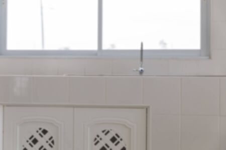 faucet and sink on counter and cabinet in modern kitchen (blurry defocused for interior background)の写真素材