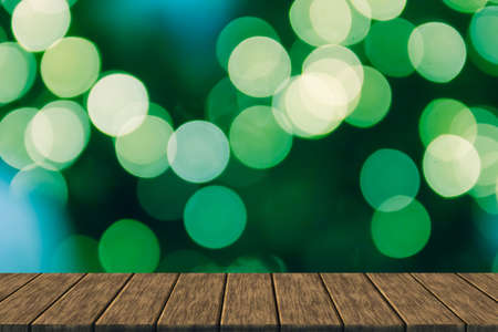 defocused blurry christmas bokeh light (blur background with wood table top for display or montage your product)の写真素材