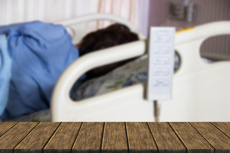 asian woman patient sleeping in hospital for recovery (blur background with wood table top for display or montage your product)の写真素材
