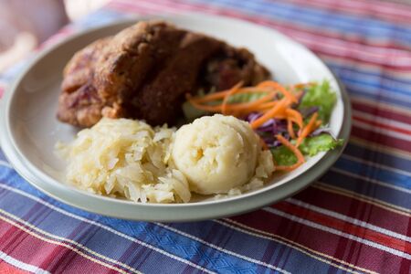 German pork knuckle hocks with mashed potatoes, sauerkraut and vegetableの写真素材