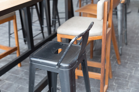brown wooden table with stool at patio of buildingの写真素材