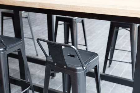 brown wooden table with stool at patio of buildingの写真素材
