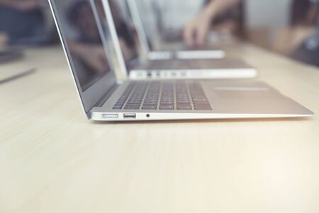 many computer notebook on wooden table, vintage toneの写真素材