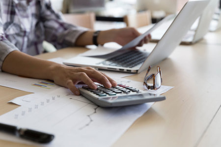 woman working with calculator, business document and laptop computer notebook
