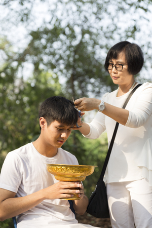 Chiang Mai, Thailand - April 30, 2016: parent cut hair of their son before buddhist monk ordination ceremony at Umong temple in Chiang Mai, Thailand on April 30, 2016.のeditorial素材