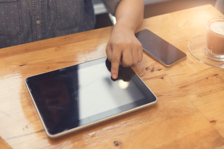 woman's hand working with tablet and smartphone for working concept, selective focus and vintage...