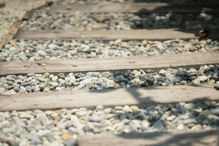 stone and wooden plank paving on walkway in garden